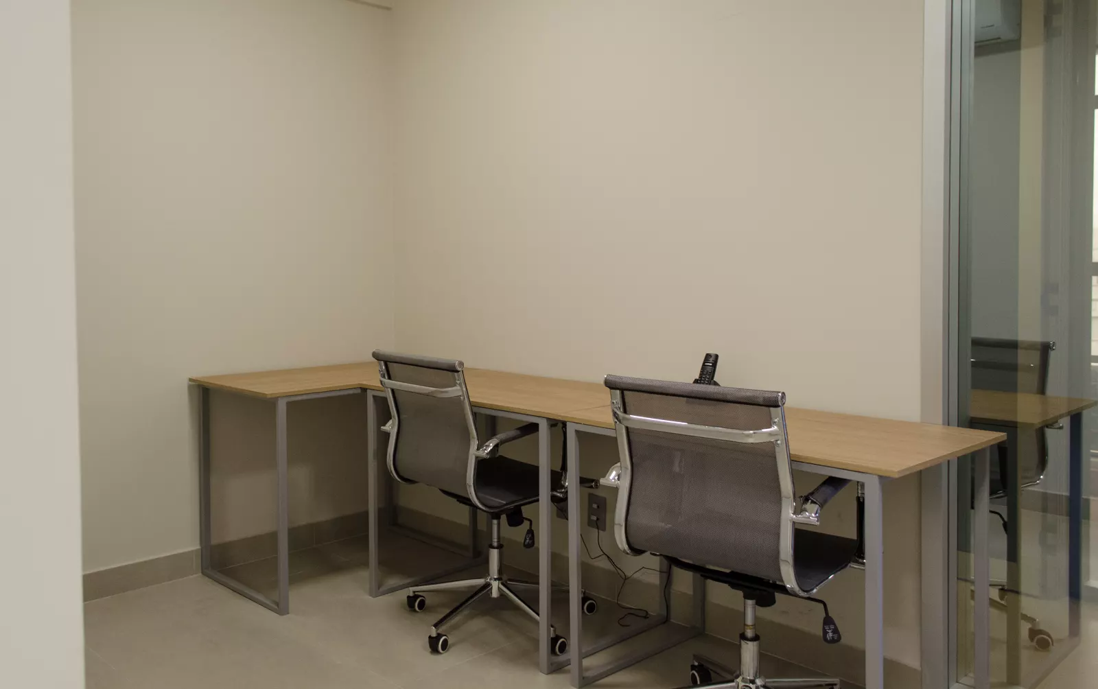 Sala privativa com duas mesas e cadeiras, de dia